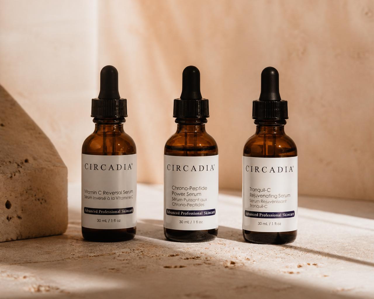 Glass serum bottles on a warm stone surface